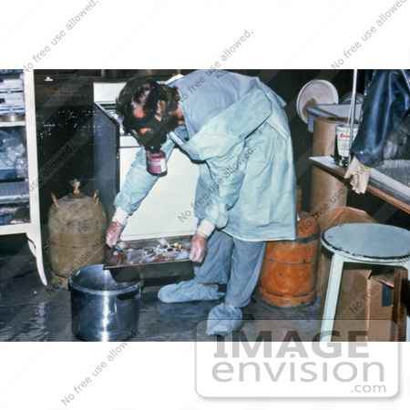Stock photography of a heavily protected technician is shown discarding blood specimens collected during the Ebola outbreak in Zaire, 1976. Researchers hurried to identify the cause of this epidemic, pinpoint its source, and halt its spread. The dise
