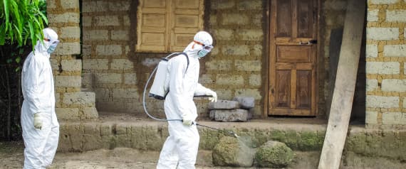A healthcare worker in protective gear sprays disinfectant around the house of a person suspected to have Ebola virus in Port Loko Community, situated on the outskirts of Freetown, Sierra Leone, Tuesday, Oct. 21, 2014
