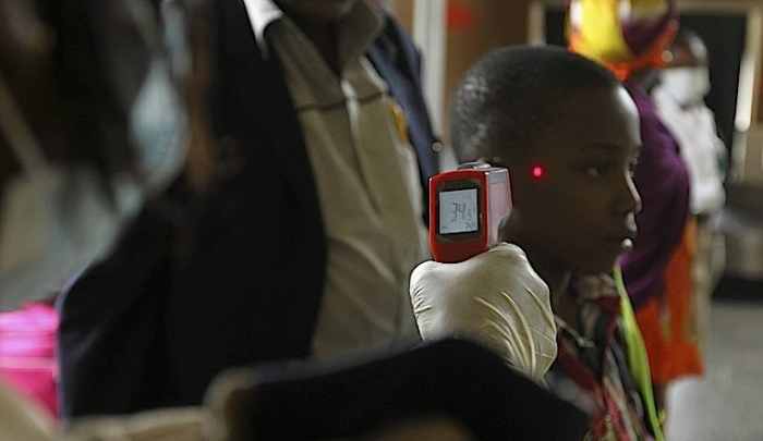 A boy's temperature is taken using an infrared digital laser thermometer at the Nnamdi Azikiwe International Airport in Abuja.