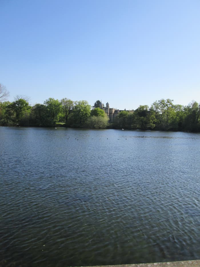 Across the Eagle Pond from the roadside is the Tudor-esque front of Snaresbrook Crown Court in its arboreal setting