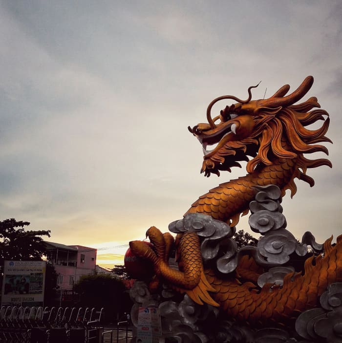A dragon statue stands firmly at the entrance, simply illustrating the name Buu Long - Long means dragons, Buu means rare and sacred.
