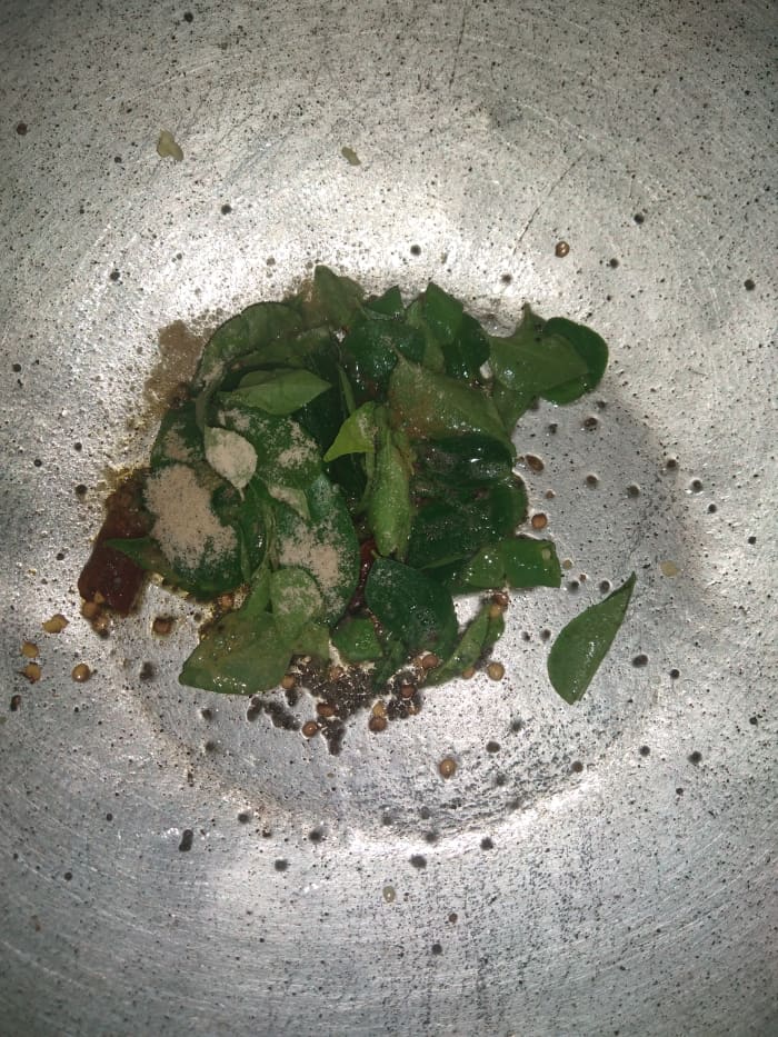 Heat oil in a pan, add mustard seeds, red chilies, green chilies, curry leaves and hing. Splutter the mustard seeds on low flame.