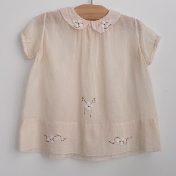 "Belle Heir" dogwood dress c. 1940 pale peach lightweight cotton gauze smock dress with peter pan collar. finished with beautiful dogwood applique + embroidery. one snap closure in back. Sh: 10.5" L: 15" Item No: