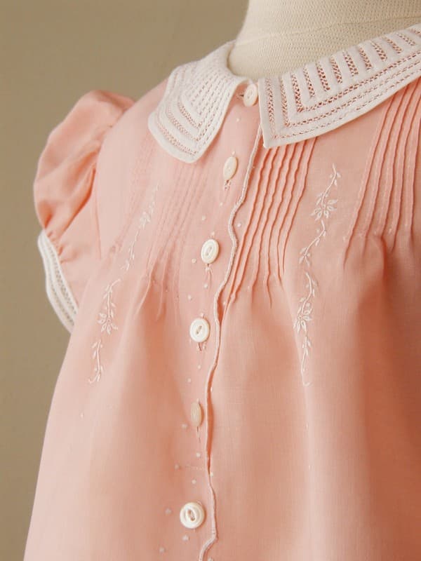 From Mrs. Bird: Salmon Cotton Dress C.1940. Unusual salmon color. Pintucks, embroidered flowers and dots, scallop design, and 13 buttons down the middle. Constructed by hand. French seams throughout. Collar and cuffs careful