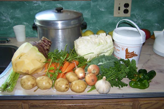 The boiling pot, the vegetables to make ready, pail of salt beef.Celery, Turnip, carrots, cabbage, onions, garlic, peppers, 2 small kale leaves, parsley, sprig of rosemary, Maggie (Loveage)and potatoes.