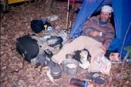 A thru-hiker called Joker is too tired and sore to do much about cooking dinner. Instead, he just lies there and stares at his gear and uncooked food.