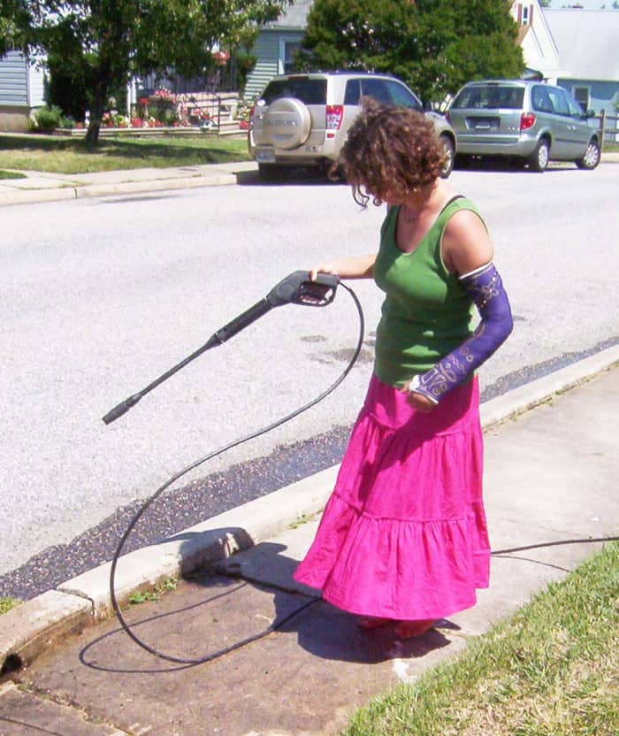 If a young lady with a broken arm can power wash the sidewalk, so can you. More powerful pressure washers need to be handled with both hands.