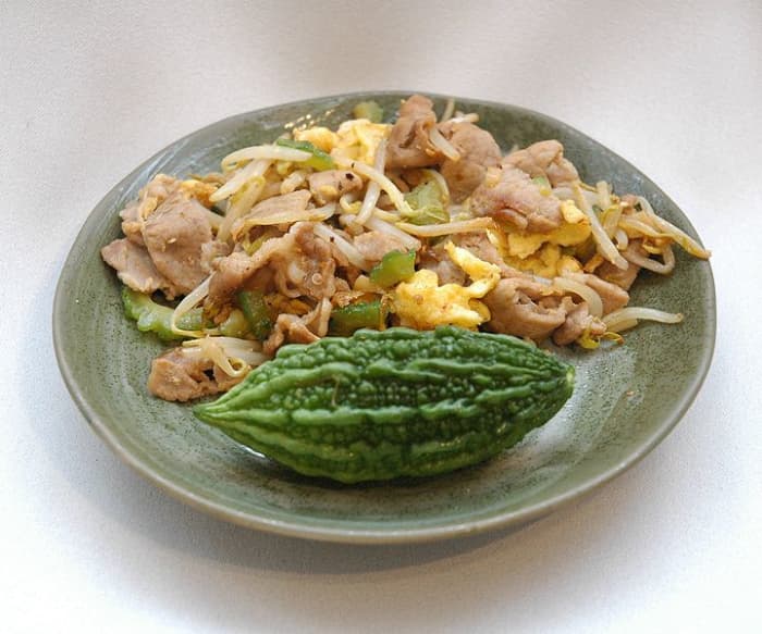 A small green bitter melon (front) and a scoop of Okinawan gy chanpur stirfry (back) photo courtesy: common.wikipedia.com