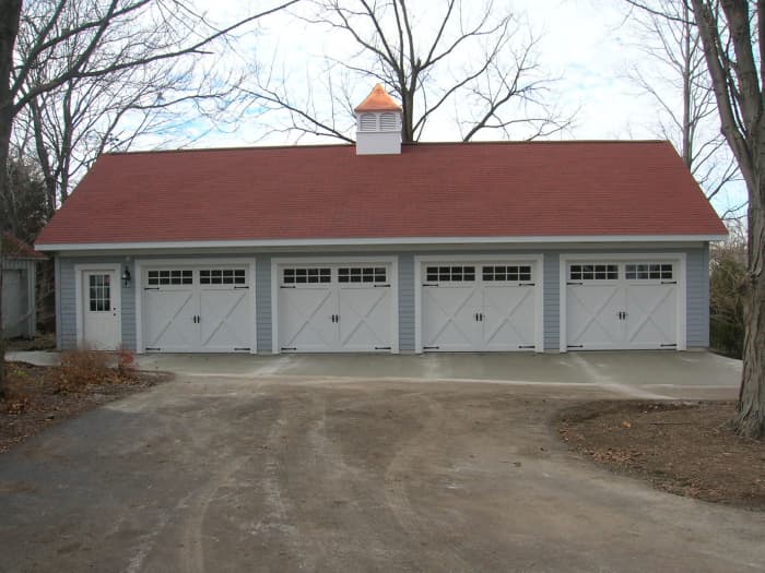 four car garage with carriage like doors in white with copper cupola