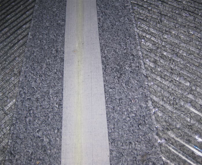 close-up of sticky side of gaffing tape and carpet seen through the heavy duty clear plastic floor mat