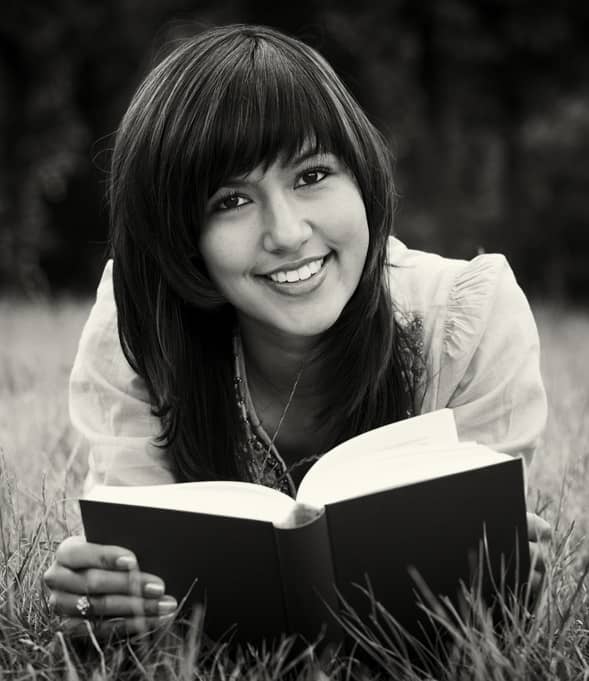 A woman models 'book reading'. She can get away with not reading this book because she has a modeling career. You, on the other hand, will actually have to read the book.