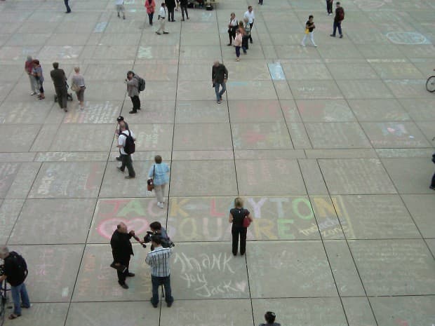 Messages in honour of Jack Layton written in chalk cover the pavement of Nathan Phillips Square in Toronto.