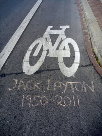 A tribute to Jack Layton written in chalk adorns a Toronto bike lane. As a member of city council, Layton promoted city cycling.