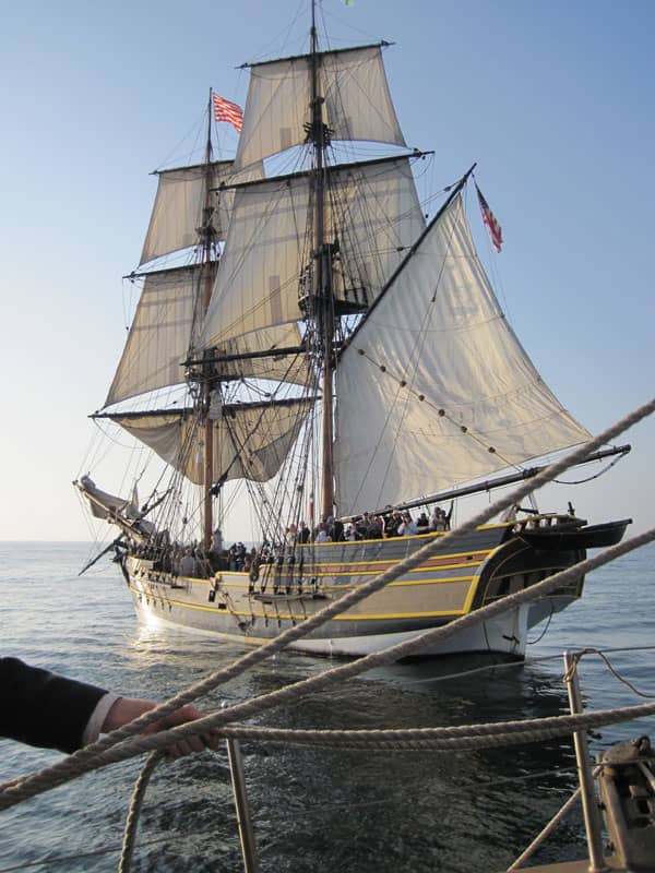 Note a crew member hauling on ropes in the foreground. Both ships' crews were constantly adjusting the sails to catch the wind as they turned about one another.