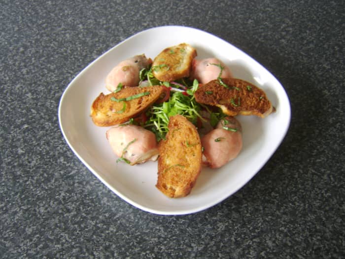 Dried prunes and chicken breast are rolled in bacon and baked, before being served with a pea shoot and radish salad and homemade croutons