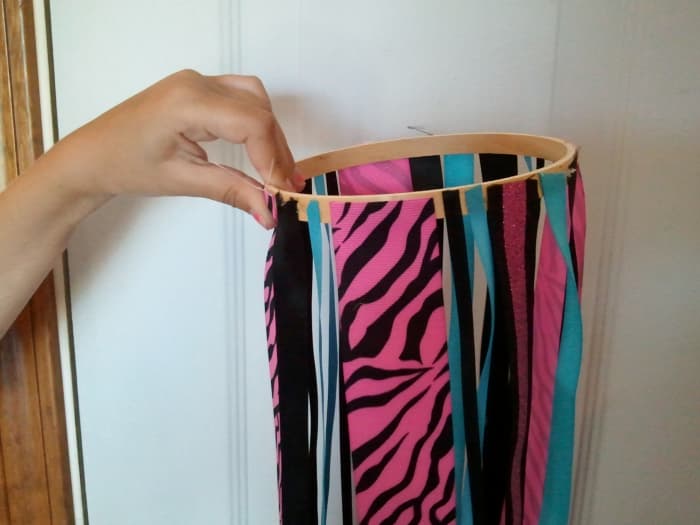 Illustration of Step 3: Take the outer ring of the embroidery hoop and attach a strip of ribbon around the outside of it.