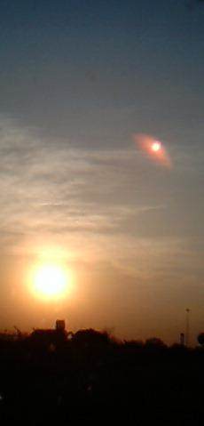 This shot shows the planet in the 1 O'clock position with a reddish glow or tail around it.