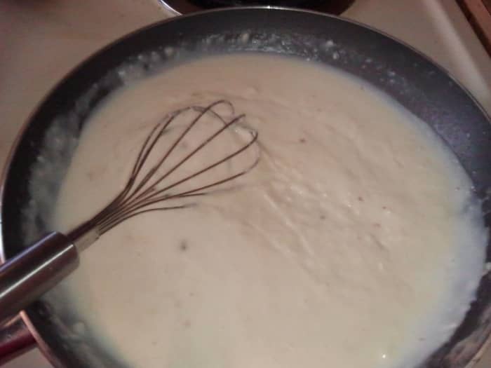 Keep adding milk in small amounts (about 1/4 cup) while whisking the crap out of your gravy to alleviate your aggressions and get out those lumps!