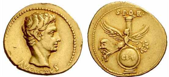 Bare head of Emperor Augustus on the left and Victory with her wings spread on the right, at the back is a column and a shield below.