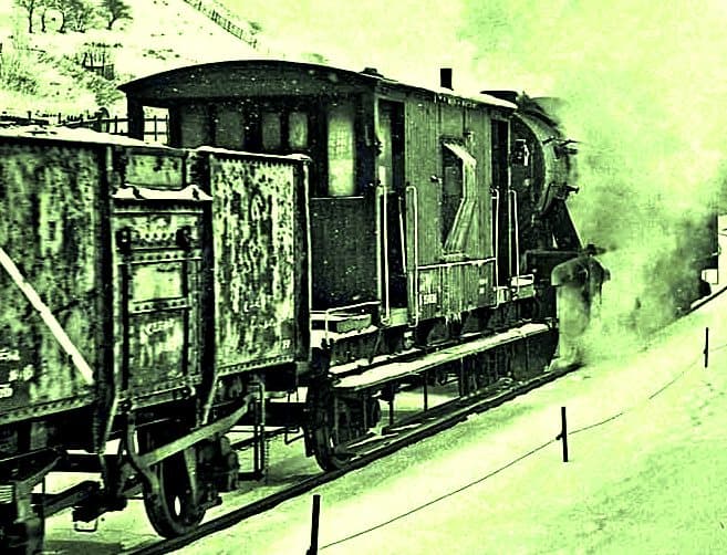 A War Department (WD) 2-8-0 takes a local pick-up goods down the line past the junction with the Great Ayton branch and below Easby Moor to the north