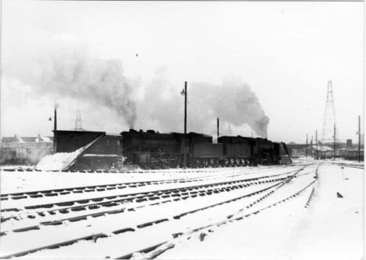 A pair of Austerity ex-WD 2-8-0 locomotives stand back-to-back with snow ploughs at either end, waiting at York for a call-out