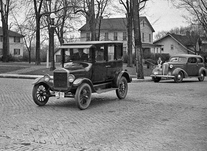 Early 1920s Model T Ford at center with 1936 Chevrolet at right