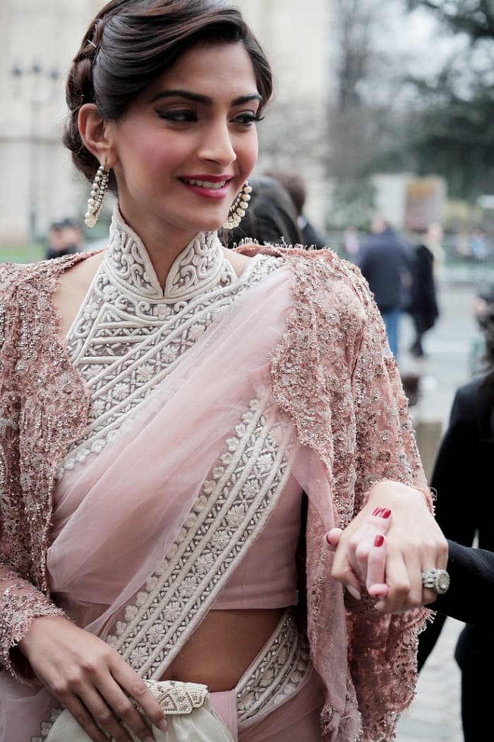 Sonam Kapoor in elegant buttoned up high neck embellished Saree blouse. Sonam Kapoor looks absolutely stunning in this simple saree with gorgeous blouse
