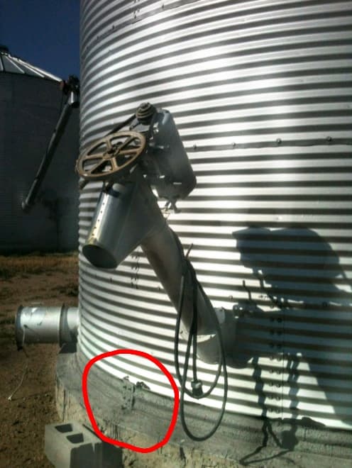 This is a typical finished anchor bolt. An L-shaped bracket is installed against the bin with bolts going into the bin wall. A wedge anchor bolt is inserted into the cement into a pre-drilled hole. A sealant can be applied over the top.