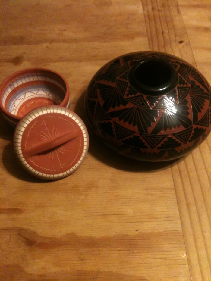 Pueblo styles of pottery, as seen at the right, honor traditional methods and use fewer colors than the newer Navajo styles such as the one at left in this photo. Notice the glaze on the Hopi pot. The Navajo one his colorful but lacks shiny glazes.