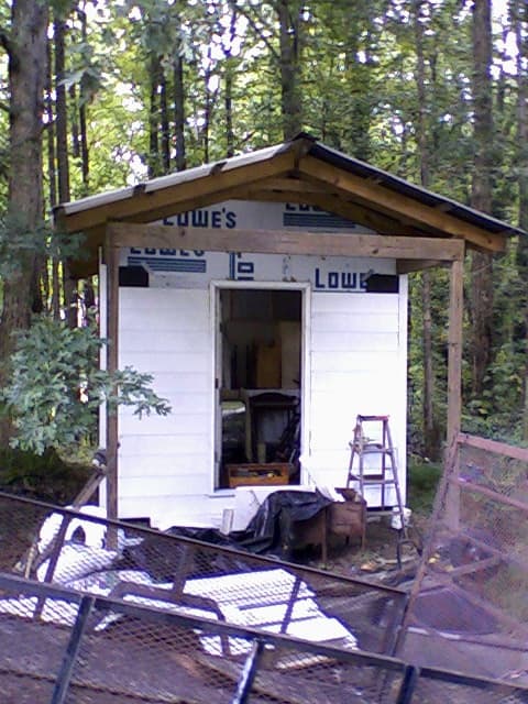 Front view, siding in process. You can see how unsightly the sheathing was! (Though the supplier probably appreciated the advertising.)
