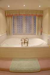 Soft, neutral colors and lace paired with splashes of color are used to create a quiet effect in this bath.