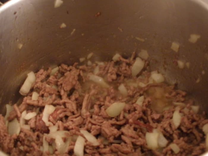 Instead of using oil, I sauteed the onions while browning the ground beef. I drained it, then put it back in the pot for the next ingredients.