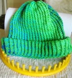My favorite hat made with my yellow (XL) circular knitting loom and using solid color combined with variegated strands of acrylic 4-ply worsted weight yarn.