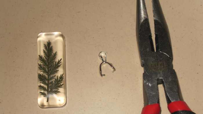 Gently spread the pinch bail open with pliers so it will fit over the top the of the pendant.