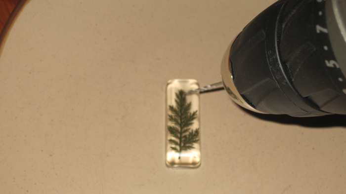 Drill a hole into the surface of the pendant, all the way through the resin. This is where you will insert the pinch bail.