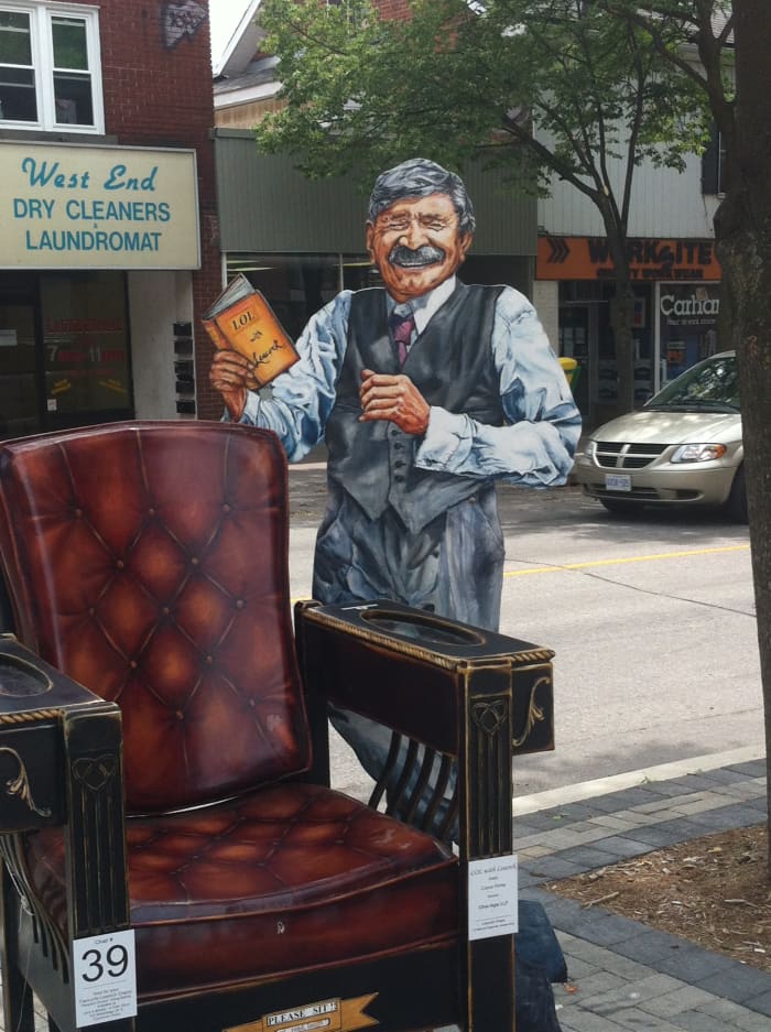 One of several chairs made to look like Stephen Leacock himself. This one he is reading from perhaps one of his own books.