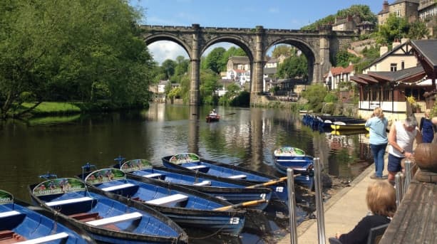 The riverside at Knaresborough with rowing boats and the 19th Century railway viaduct behind