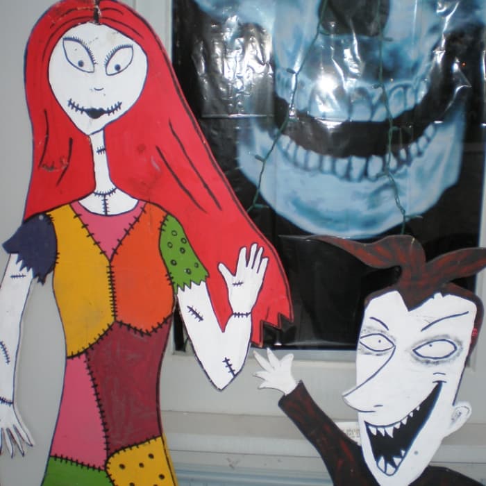 Halloween decor like Sally and Lock from The Nightmare Before Christmas wave to guests.