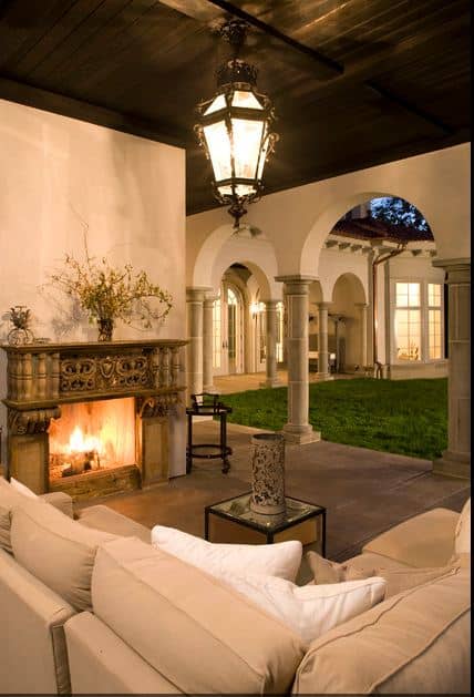 Mediterranean patio with outdoor fireplace, romantic ceiling light and pillars accent an outdoor couch