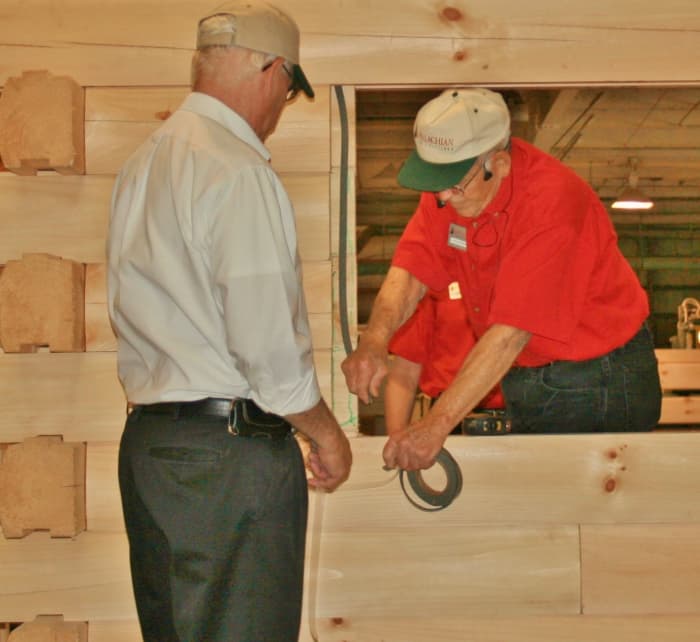 Appalachian Log Structures employees demonstrate the company's multiple techniques for sealing windows and doors.
