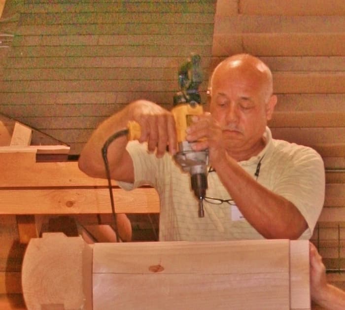 A seminar participant helps build a small cabin at an Appalachian Log Structure workshop in WV.