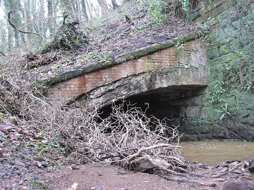 An old culvert at Waterfall/Spawood Mine, laid in on a slope against a retaining wall, and now overgrown amid woodland to the east of Guisborough