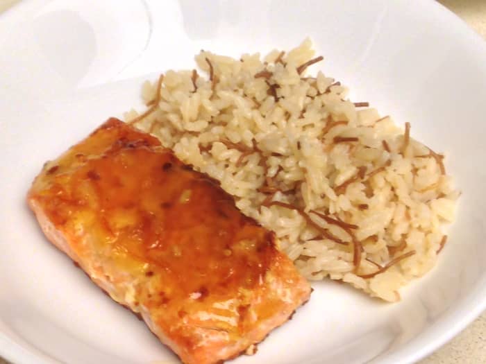 Pan seared salmon with a glaze of orange juice, lime juice, orange marmalade, and ginger. Served with rice pilaf.