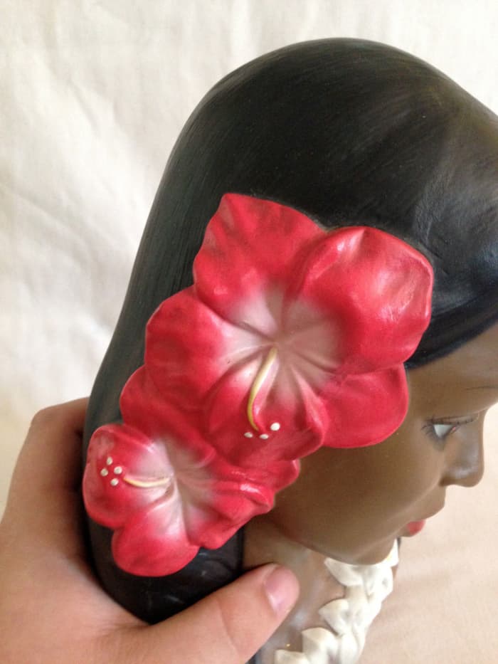 The hibiscus flower being worn in this head bust is the type that is traditionally worn by Polynesian, Tahitian, and Hawaiian girls.