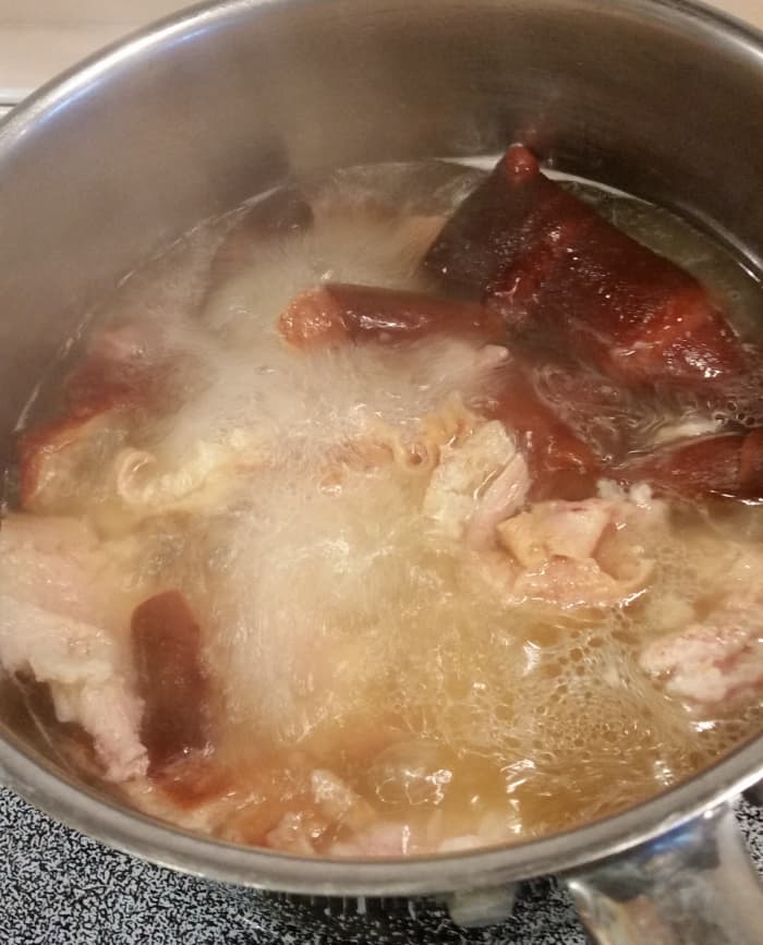 I boil some of the fat and rind cut from the ham the day before. Save the resulting broth and discard the fat and rinds. Add the broth as part of the 8 cups of liquid in the soup.