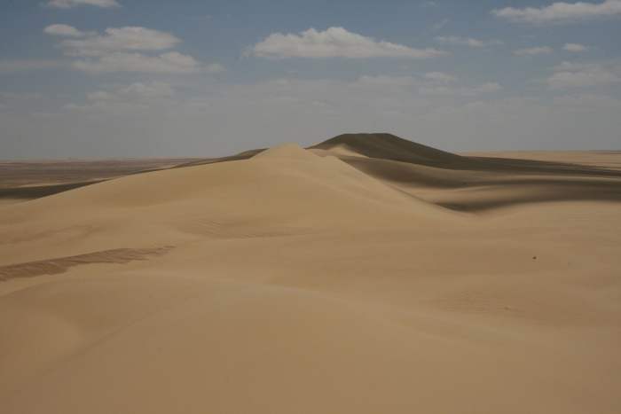The Qattara Depression the largest in the world. The Qattara Depression lies 436 feet below sea level, and its bottom is covered with salt pans, sand dunes, and salt marshes.