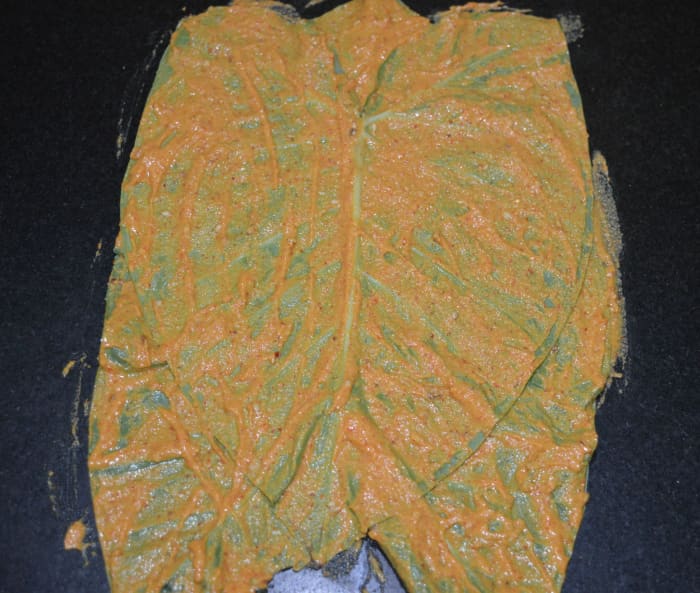 Place another leaf on it while the tip pointing downwards. Apply the paste on it in a similar way. Similarly, place total five leaves and apply the paste.