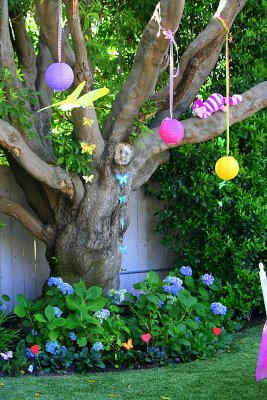 Paper lanterns and a Cheshire cat decorate this tree, found at http://partywishesscv.blogspot.com/2009/07/mad-hatter-tea-party.html