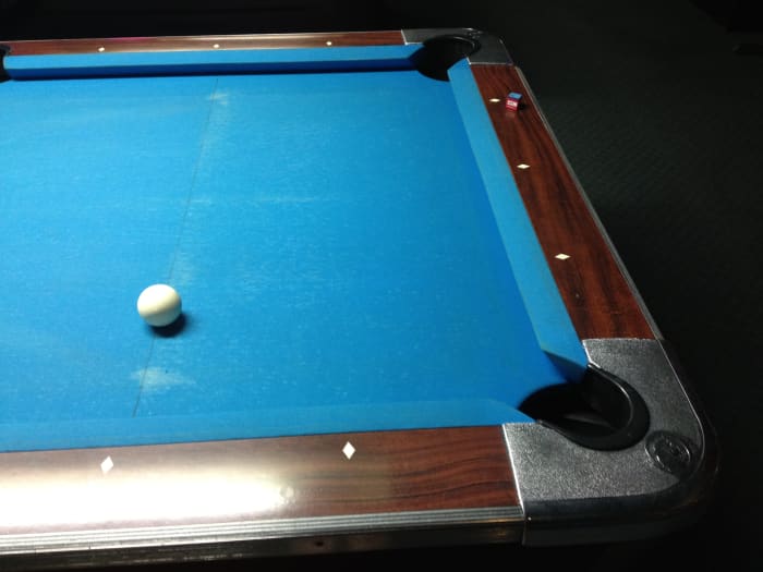 The second diamond is tough to see with the glare off the table, but the four balls are to the left of this photo. The cue ball is on the point where the imaginary lines described above intersect.