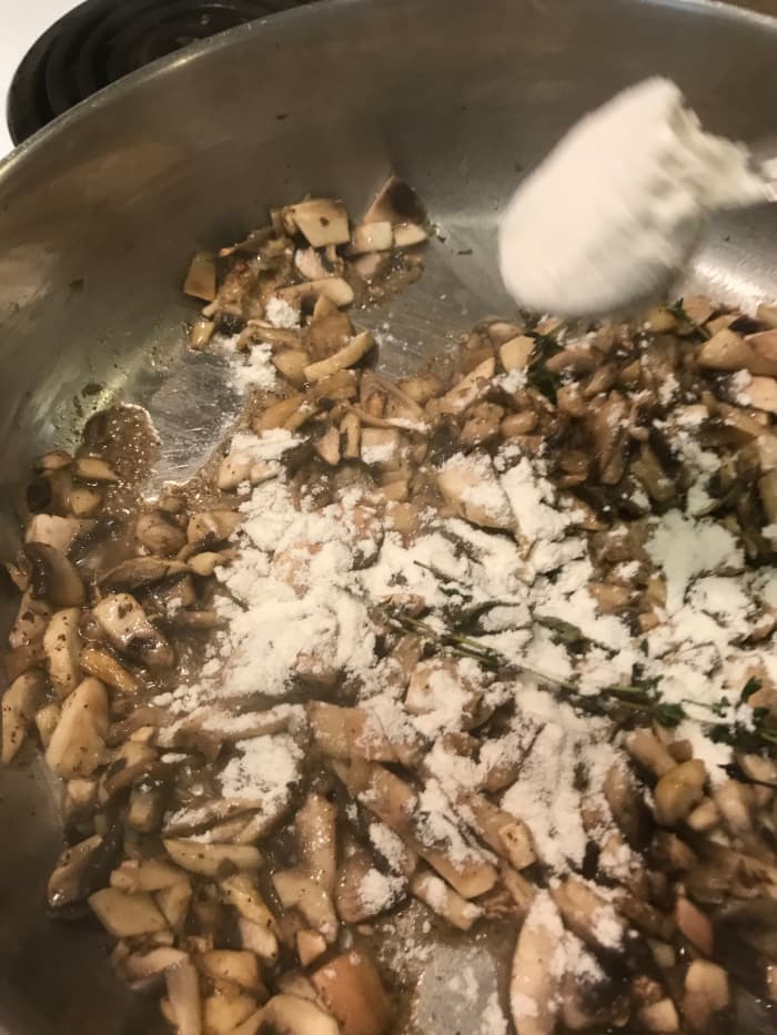 Once the mushrooms release their liquid, sprinkle in the flour. Stir it well, until fully incorporated. Stir in the chicken broth and half and half.